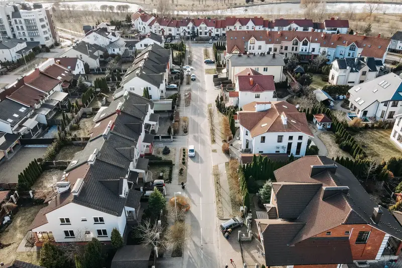Aerial view of a suburban neighborhood: rows of single-family homes along a residential street
